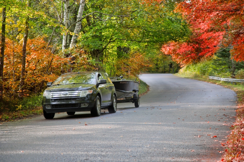 Vehicle driving a rural Jefferson County-style road lined with fall foliage